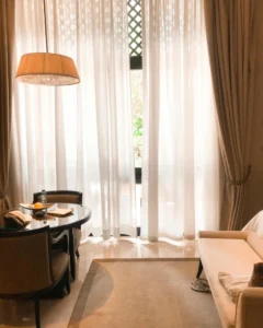 Diseño refugio emocional: salón cálido con cortinas filtrando luz suave